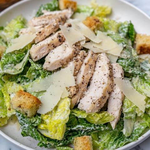 A fresh, classic Chicken Caesar Salad, featuring juicy grilled chicken and salty, sharp Parmesan.
