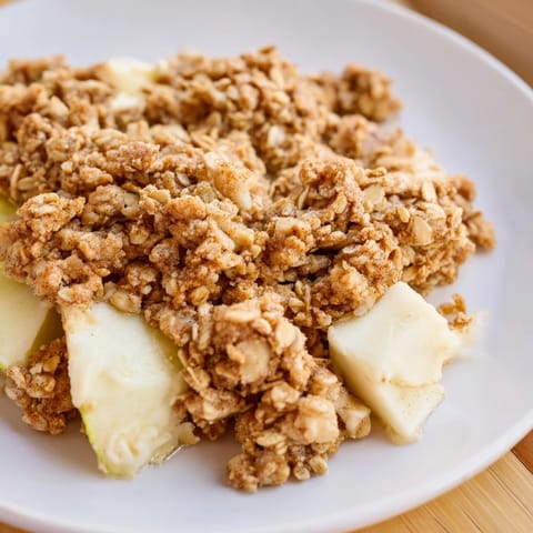 Warm, bubbling apple crumble, a comforting dessert with golden, buttery topping, ready to serve.