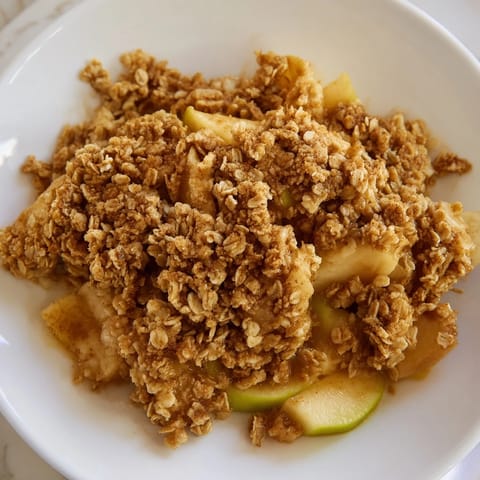 A close-up shot of a freshly baked apple crumble with a crisp, golden crumble crust.