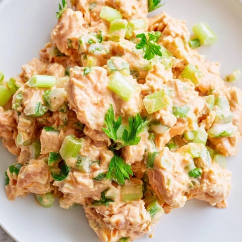 Close-up view of a protein-packed tuna salad mixed with fresh lemon juice, served in a rustic ceramic bowl.