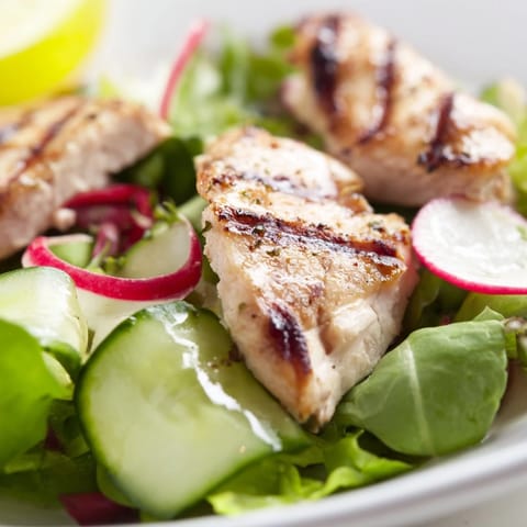 Freshly grilled chicken slices rest atop vibrant mixed greens, crisp cucumber, and peppery radish in this Spring Detox Chicken Salad, drizzled with a zesty lemon vinaigrette.