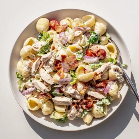 Creamy BLT Chicken Pasta Salad features tender shells, smoky bacon, crisp romaine, juicy cherry tomatoes, and grilled chicken in a tangy mayo dressing.