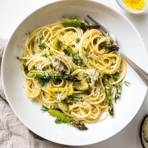 Tender asparagus and sweet roasted garlic cloves glisten with olive oil on a forkful of spaghetti in this Roasted Garlic & Asparagus Pasta.  