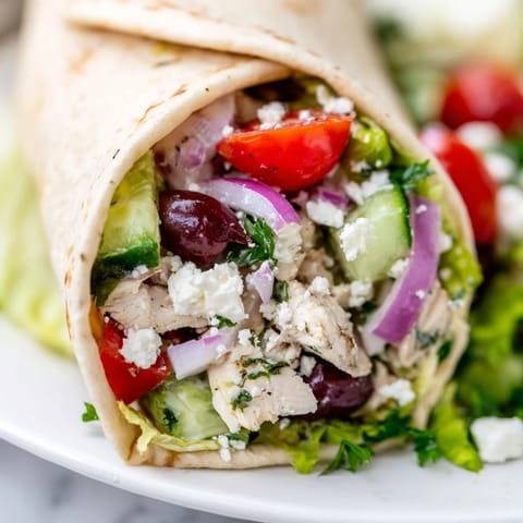 Juicy lemon-marinated chicken and crisp Greek salad tucked in a warm, soft tortilla for a fresh lunch.