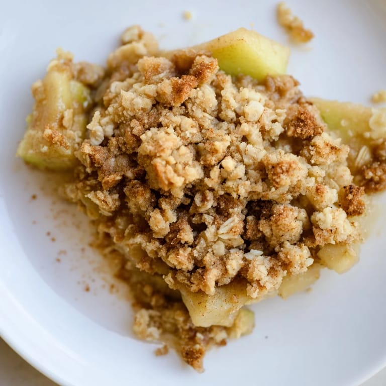 Delicious homemade apple crumble with warm, spiced apples, perfect with vanilla ice cream.