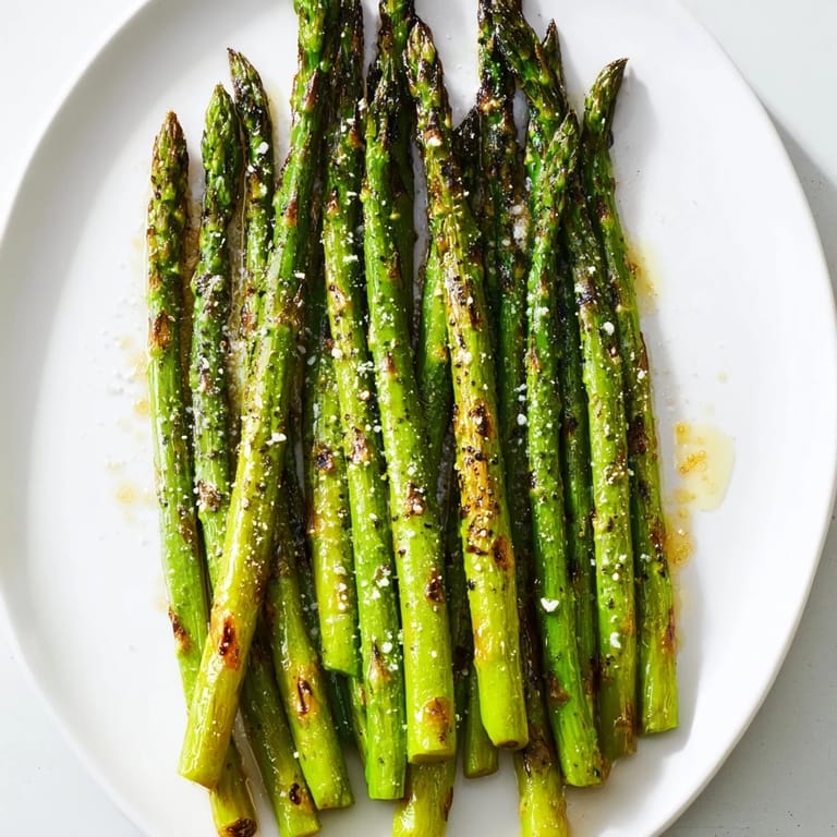 Freshly grilled asparagus, lightly salted and peppered, awaiting a squeeze of zesty lemon for a flavorful bite.