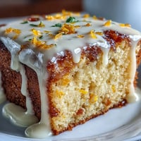 A slice of Heavenly Blood Orange Yogurt Cake shows a moist crumb and glossy citrus icing.